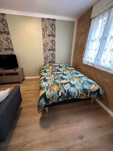 1 dormitorio con 1 cama con colcha colorida en Le Jacquard en Calais