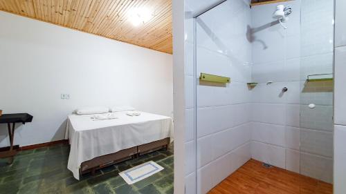 Cette chambre dispose d'une douche, d'une table et d'une salle de bains. dans l'établissement Rancho Hanna - Pousada, Camping e Comidaria, à Iporanga