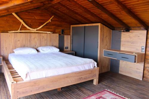 a bedroom with a bed in a wooden cabin at Likya Garden Life in Gâvurağılı