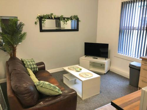 a living room with a couch and a tv at Bank Street Apartment 7 in Blackpool
