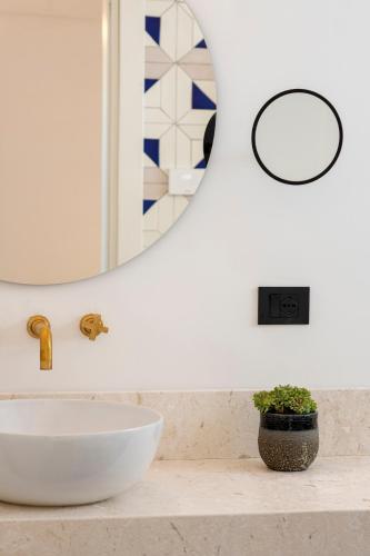 a bathroom with a white sink and a mirror at OraBlu Exclusive Villas in Ischia