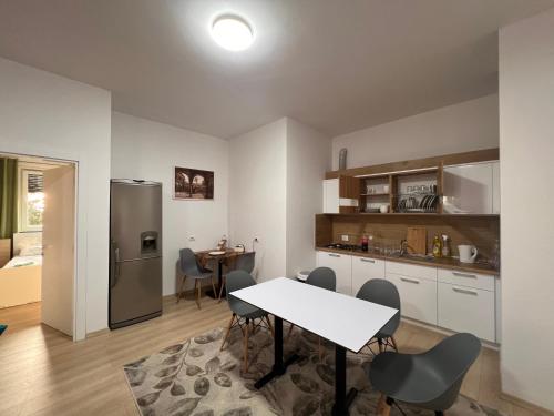 cocina y comedor con mesa y nevera en Kino Apartment, en Tirana