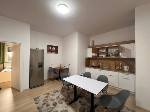 a kitchen and dining room with a table and a refrigerator at Kino Apartment in Tirana