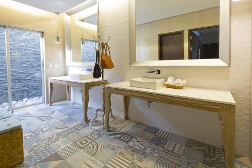 a bathroom with two sinks and a mirror at Hotel Villa Los Candiles in San José