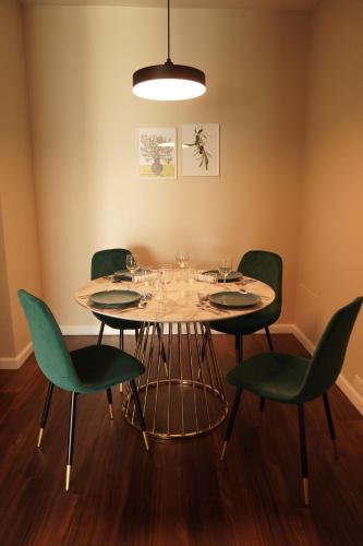 a dining room with a table and green chairs at Lux Oasis in West Hollywood, Free Parking & Swimming pool in Los Angeles