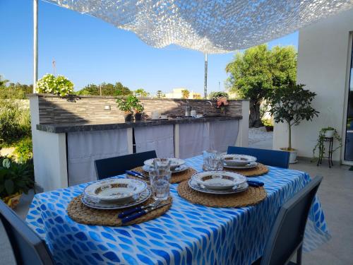 a table with a blue and white table cloth on a patio at Suite12 in Marsala