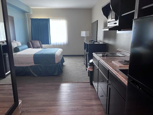 a small hotel room with a bed and a kitchen at Cobblestone Inn & Suites - Fort Dodge in Fort Dodge