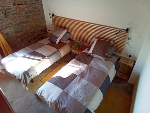 two beds sitting next to each other in a room at La Borda de Allué in Huesca