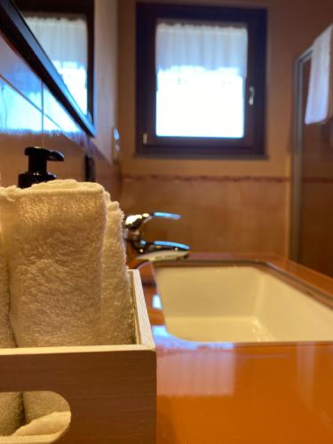 a bathroom with a sink and a tub with towels at Villa Mattei Franciacorta in Villa Pedergnano