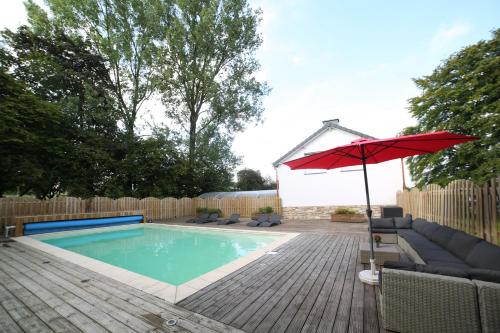 a swimming pool with a red umbrella and a chair at Dolce Villa Pool and Wellness in Francorchamps