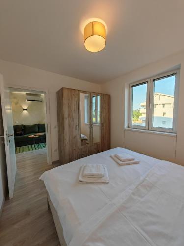a bedroom with a large bed with two towels on it at Apartman Holiday 1 - Srebrno jezero in Veliko Gradište