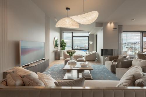 a living room with a couch and a tv at Vindlys Luxury Penthouse Apartment in Tromsø