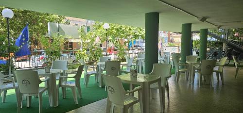 - une rangée de tables et de chaises sur la terrasse dans l'établissement Hotel Napoleon, à Cesenatico