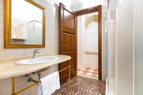 a bathroom with a sink and a mirror and a shower at L'Antico Palazzo in Vernole