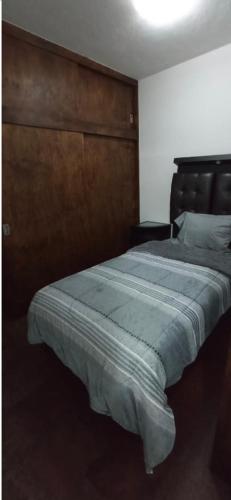 una camera con un grande letto con testiera in legno di Depa55-2 a Toluca