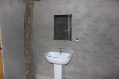 bagno con lavandino bianco e specchio di Forest Tree Top Holiday Resort a Buttala