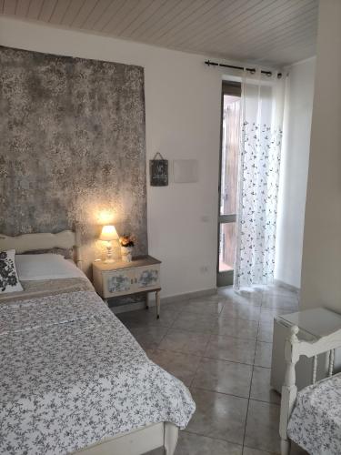 a bedroom with a bed and a table with a lamp at Grotta dei Puntali B&B in Carini