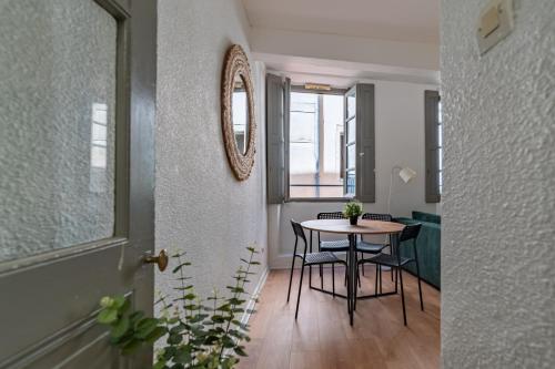 Cette chambre comprend une table, des chaises et un miroir. dans l'établissement Centre ville - Proche des Arènes et de la Maison Carrée, à Nîmes