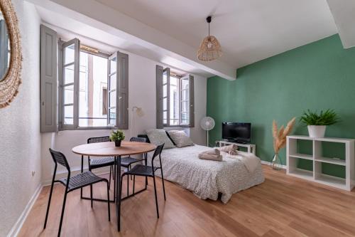 une chambre avec un lit, une table et des chaises dans l'établissement Centre ville - Proche des Arènes et de la Maison Carrée, à Nîmes