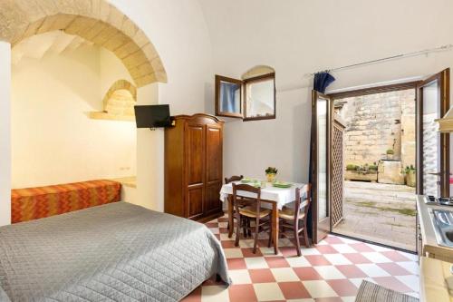 a bedroom with a bed and a table and a kitchen at L'Antico Palazzo in Vernole