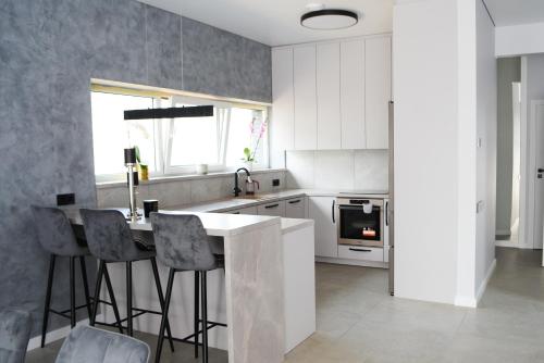 a kitchen with white cabinets and a table and chairs at Koala rest house in Druskininkai