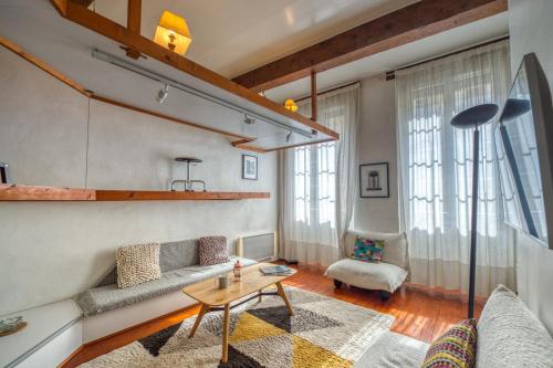 uma sala de estar com um sofá e uma mesa em Atypique - Hypercentre / Place aux Herbes em Grenoble