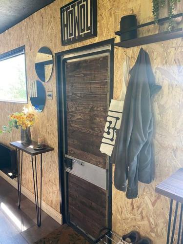a wall with a wooden door and a sign on it at Horse Truck Tiny Home in Swords
