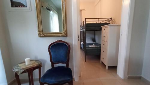 um corredor com uma cadeira azul e um espelho em Agathi's House em Preveza
