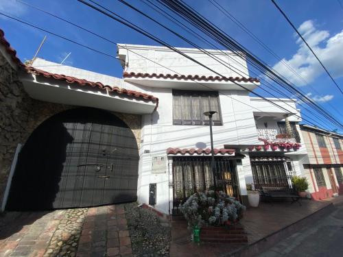 ein weißes Haus mit einem Tor und einer Garage in der Unterkunft Home Mark Casa Boutique in Paipa