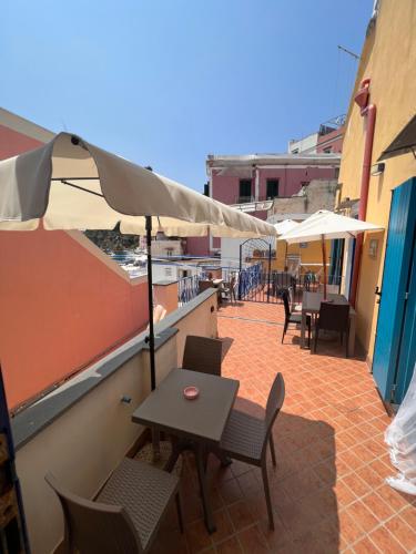 a table and chairs with an umbrella on a patio at Casetta Giulia in Procida