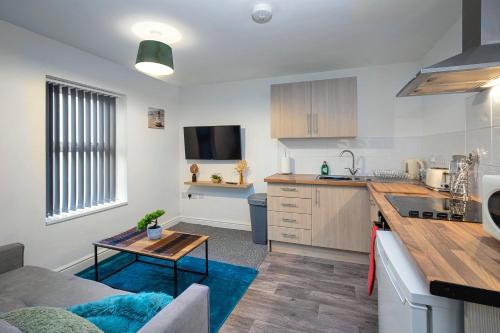 uma cozinha e sala de estar com um sofá e uma mesa em Bank Street Apartment 4 em Blackpool