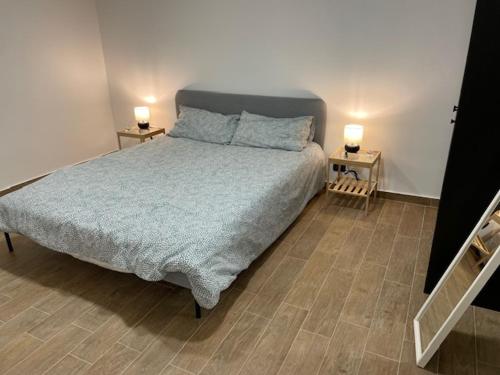 um quarto com uma cama e duas lâmpadas em duas mesas em Casa Serena em Giardini Naxos