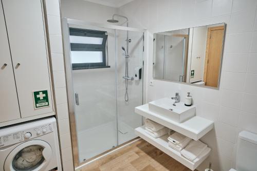 a bathroom with a sink and a washing machine at feel... Azores - apartments in Velas