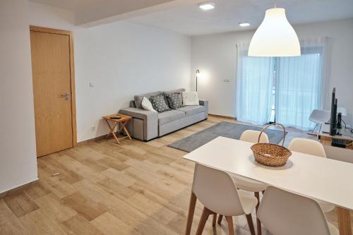 a living room with a table and a couch at feel... Azores - apartments in Velas