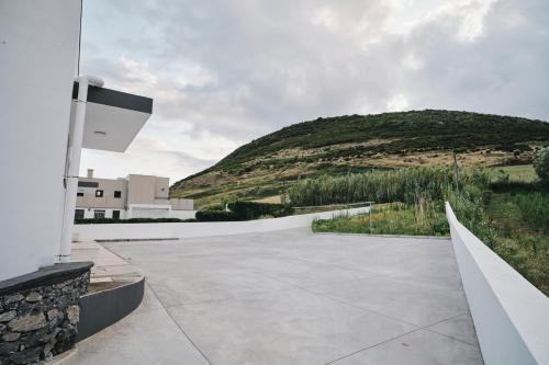 a view of a building with a hill in the background at feel... Azores - apartments in Velas