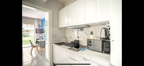 une cuisine avec des armoires blanches et un comptoir dans l'établissement appartement front de mer, à Deauville