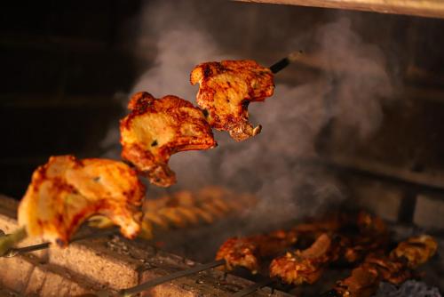 three pieces of food cooking on a grill at Fenix Villa in Zarritʼapʼ