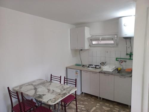 uma cozinha com uma mesa e uma mesa e cadeiras em Markos Apartments Sutomore em Sutomore