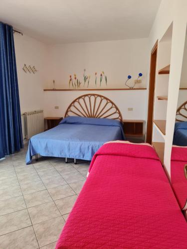 a bedroom with two beds with red sheets at Le Case dei Pescatori - Roseto in Ponza