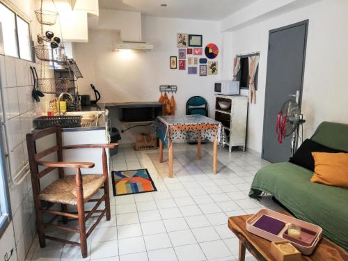 kuchnia i salon z kanapą i stołem w obiekcie Charmant appartement en centre-ville médiéval w mieście Gigean