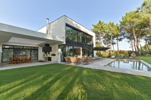 Cette maison moderne dispose d'une piscine et d'une cour. dans l'établissement Villa Palm Green, aux Mathes