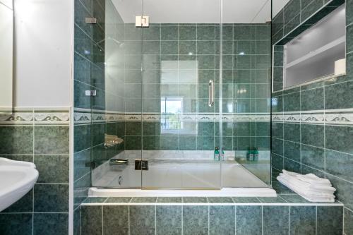 ein Bad mit einer Dusche, einer Badewanne und einem Waschbecken in der Unterkunft JTs Key Largo Escape in Jewfish