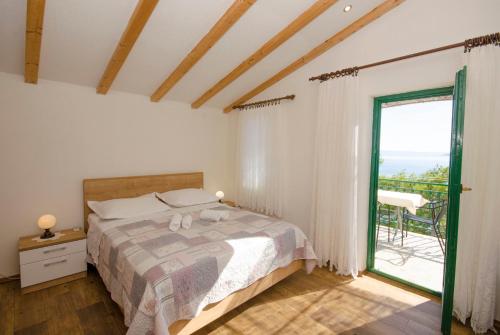 ein Schlafzimmer mit einem Bett und einem großen Fenster in der Unterkunft Apartments Mira in Brela