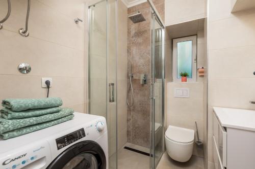 a washing machine in a bathroom with a shower at Apartment Salita Calvario in Rijeka