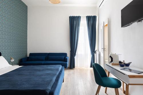a bedroom with a bed and a desk and a blue couch at Sapore di Mare al Borgo in Gaeta