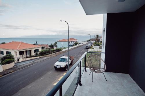 a balcony with a car parked on a street at feel... Azores - apartments in Velas