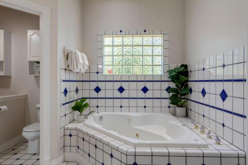 e bagno con vasca e piastrelle bianche e blu. di Driftwood Retreat Upstairs a Blaine