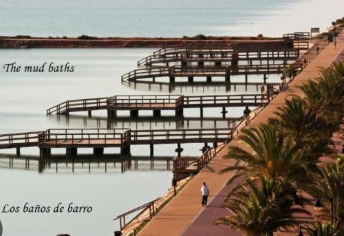 a man walking on a walkway next to the water at Casa Bonita in San Pedro del Pinatar