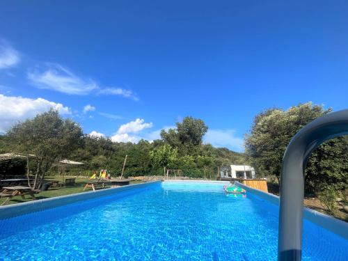 a swimming pool at a resort with people swimming in it at La Cabane de Mercone Crenu in Corte