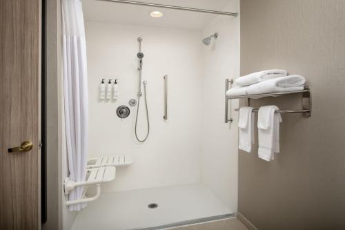 a white bathroom with a shower and a shower curtain at SpringHill Suites by Marriott Atlanta Buford/Mall of Georgia in Buford